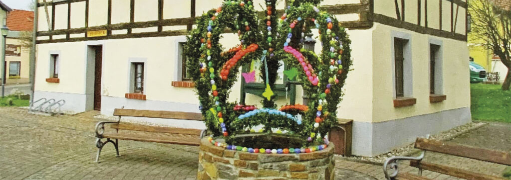 geschmückter Osterbrunnen mit bunt bemalen Ostereiern